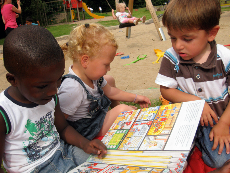 Kinder betrachten gemeinsam ein Bilderbuch